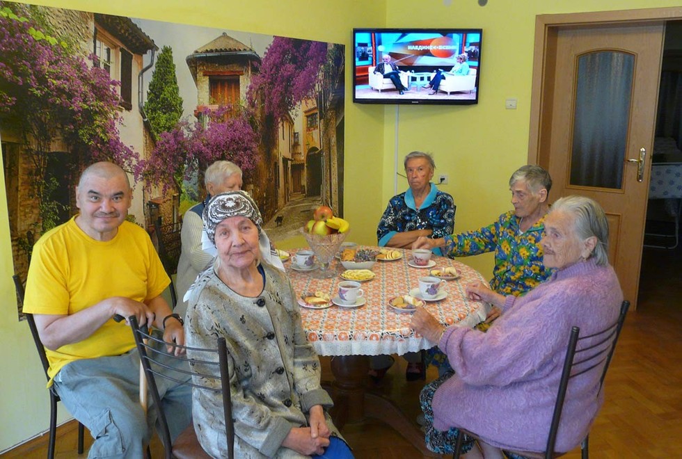 Пансионат «Времена года» расположен в живописной местности в пределах Новохоперска Воронежской области. Наш дом престарелых — это безбарьерная среда, в которой пожилые люди с любыми диагнозами ощущают комфорт, уют. Они окружены вниманием и заботой.  Наши постояльцы К нам поступают люди пожилого возраста с различными диагнозами — артрит, старческое слабоумие, рассеянный склероз и многие другие. Мы оказываем услуги пожилым людям с ограниченными возможностями, лежачим и тяжелобольным. Для каждого постояльца подготавливается индивидуальная реабилитационная программа, направленная на скорейшее выздоровление. Каждый пожилой человек получает комплексный уход.  Организация ежедневного интересного досуга Жизнь в социуме для пожилых людей, это далеко не всегда счастливая жизнь в окружении внуков. Многие в старости остаются одни, другие — проживают в семьях, но взрослым людям просто не хватает времени на организацию ежедневного досуга своим пожилым родственникам. В стенах дома престарелых «Времена года» в Новохоперске для пожилых людей подготавливается интересная программа досуга ежедневно. У нас работают различные кружки, секции, которые с удовольствием посещают пенсионеры. В них они танцуют, поют, вяжут, рисуют и др. Мы вместе с ними подготавливаем концертные программы, посвященные различным праздникам. Наши постояльцы принимают в них участие. С теми же, кто отказывается от участия, отдельно беседуют сотрудники. Каждый пенсионер в нашем пансионате найдет такое занятие, которое ему точно придется по душе. У многих появляются новые хобби, увлечения.  Пожилые люди у нас могут не только принимать участие в программе досуга, но и проводить время в комфортных и уютных комнатах. Либо же прогуливаться на свежем воздухе по безопасной территории пансионата. В наших стенах пенсионеры забывает о том, что такое одиночество. Жизнь каждого максимально наполнена красками и ежедневной программой досуга.  Психологическая поддержка Наши постояльцы не только получают физическую помощь, но и психологическую поддержку. Очень часто пожилые люди в